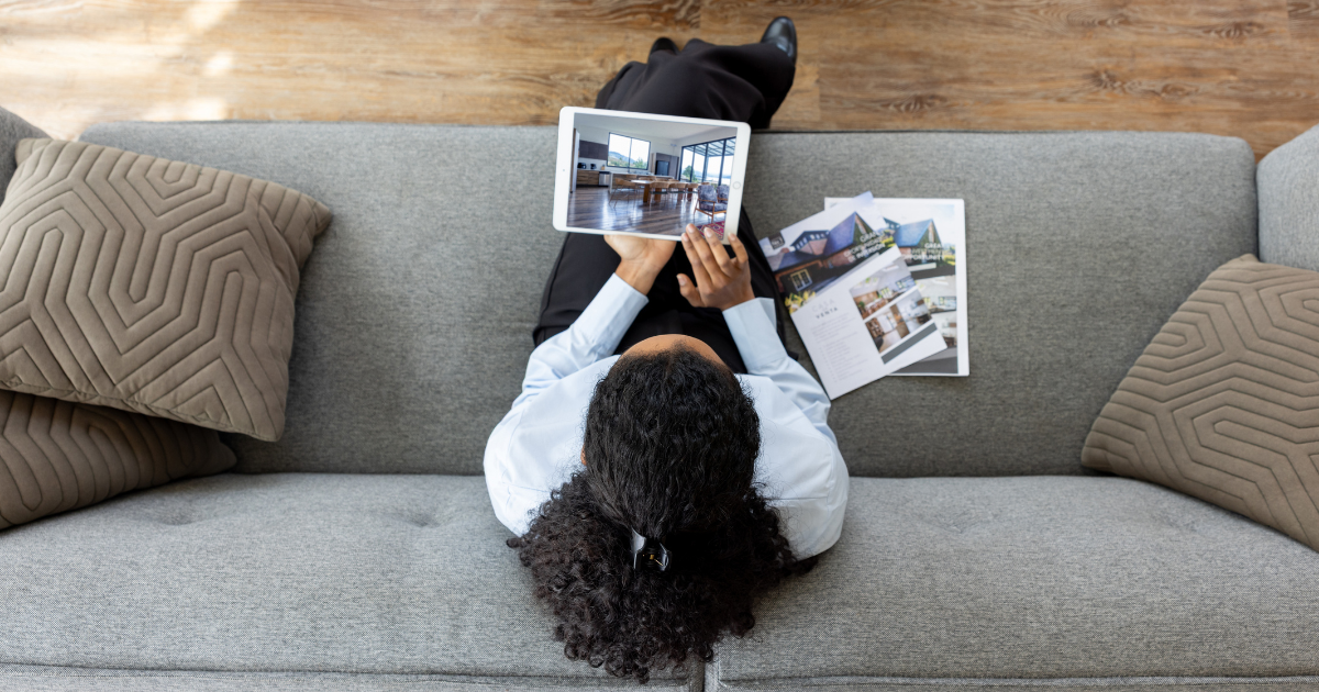 Woman on a sofa looking at home listings on a tablet