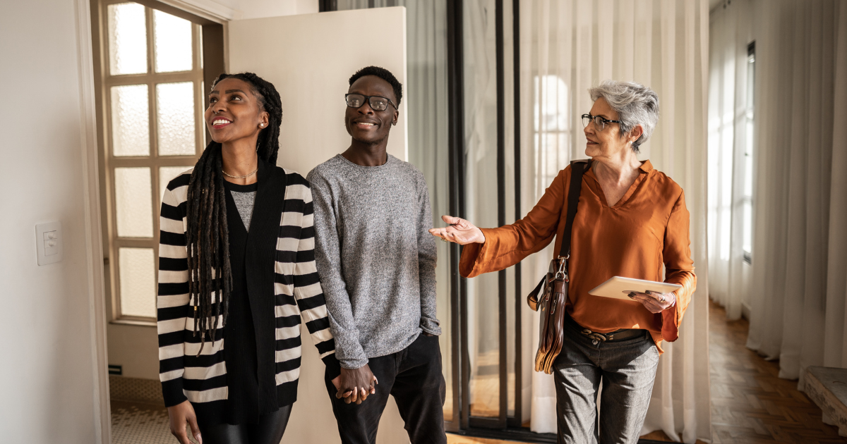 Real estate agent showing a young couple a home